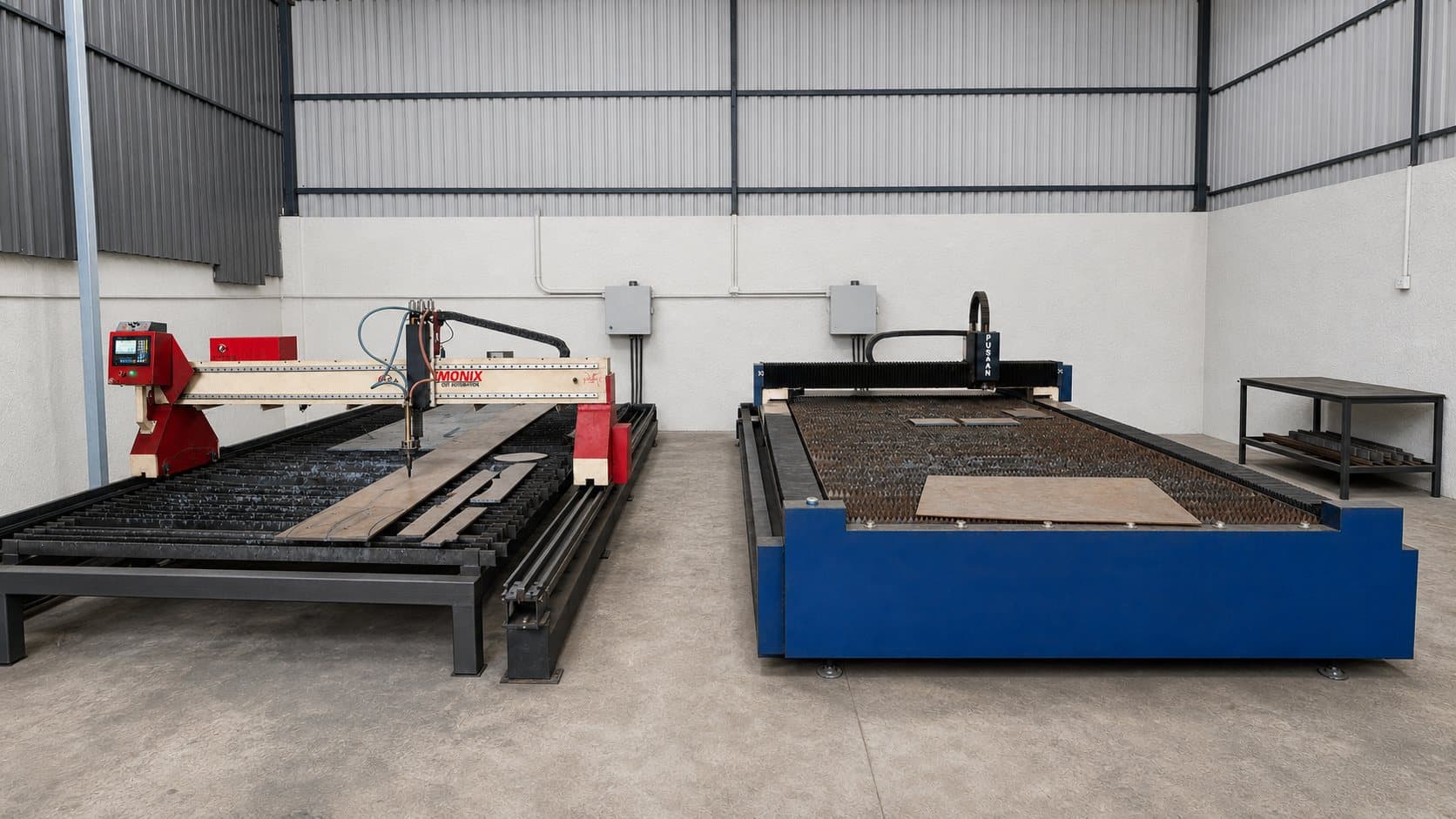 Fabrication bay with a CNC plasma table and a fibre laser cutting bed