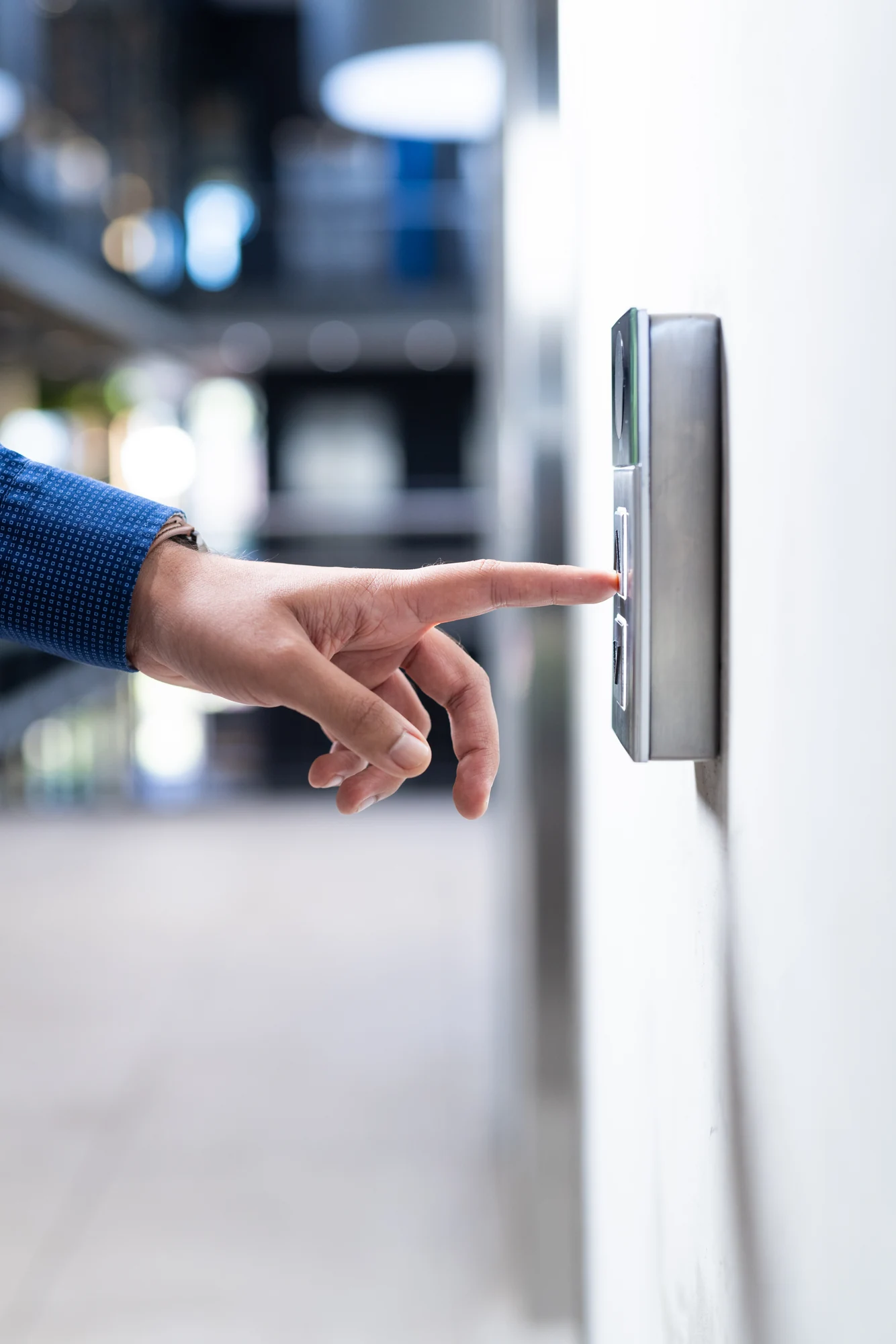 A person operating a wall-mounted security access panel