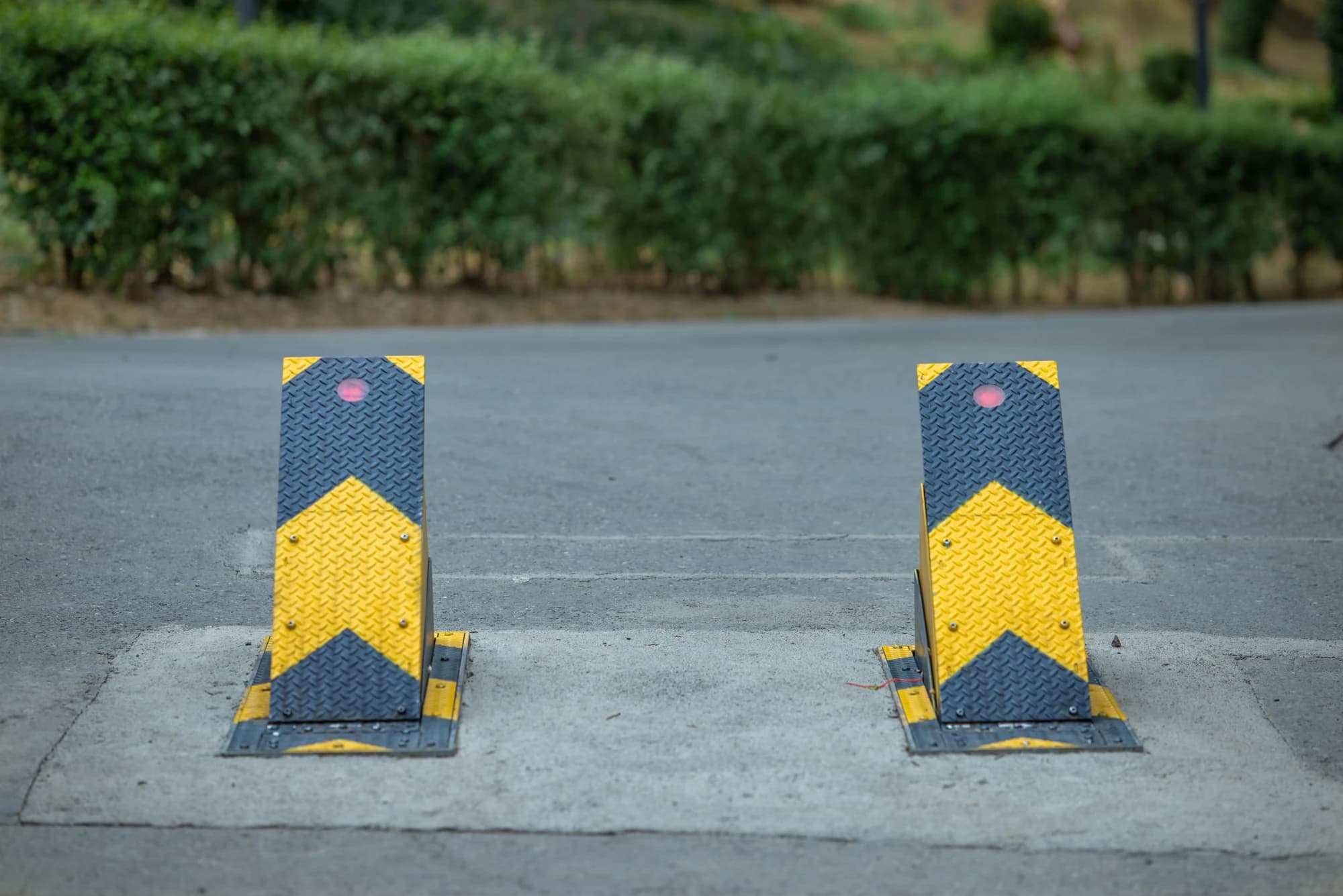 Two raised steel road blockers with yellow warning chevrons