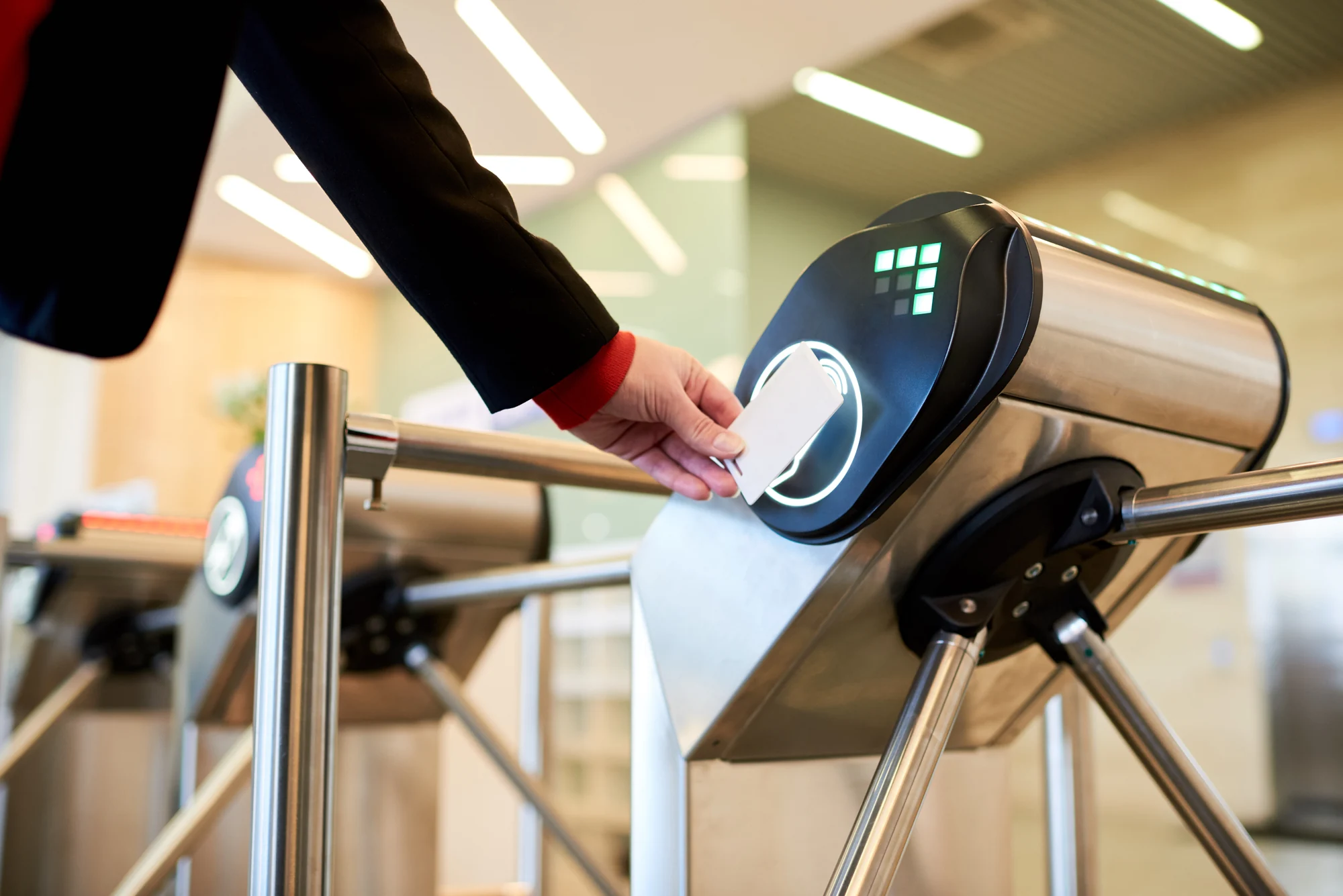 Access card presented at a stainless-steel tripod turnstile