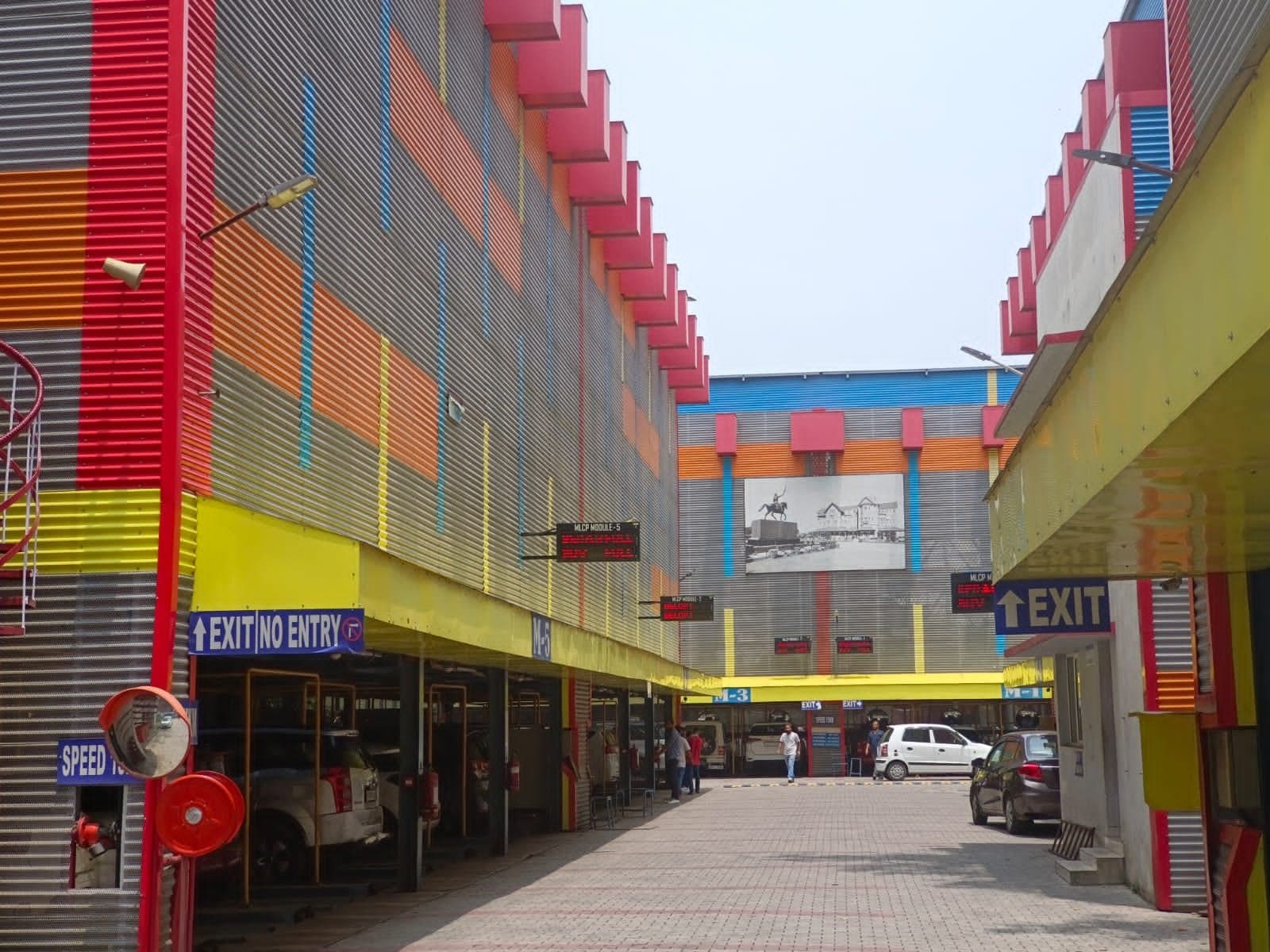 Driveway between multi-level puzzle parking modules with display boards