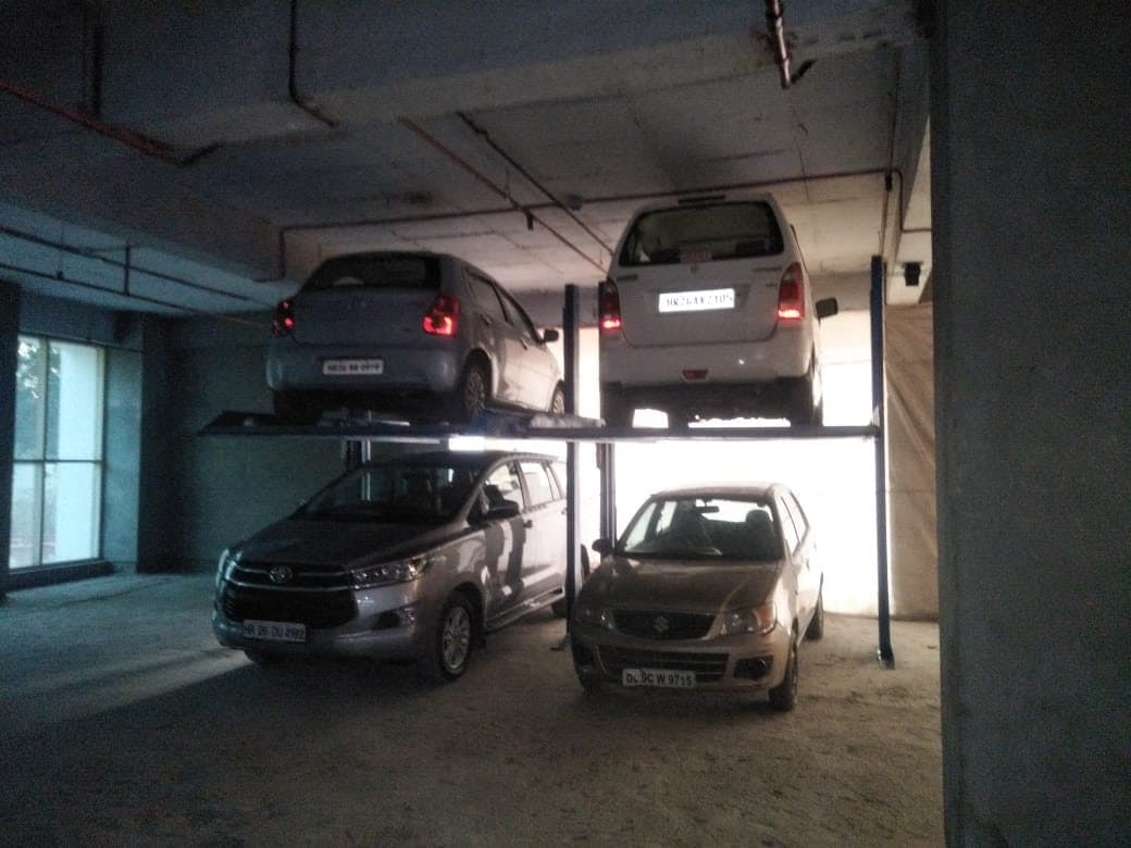 Two-post stack parking in a basement with two cars raised and two below